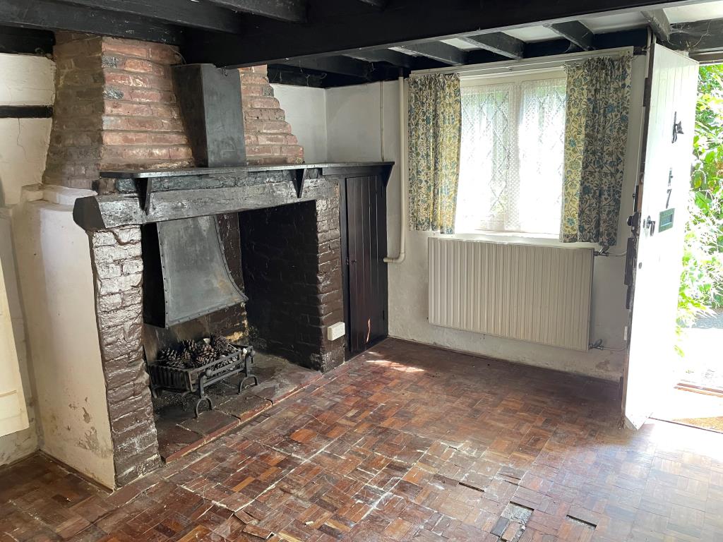 Lot: 128 - CHARACTER COTTAGE WITH POTENTIAL IN SOUGHT AFTER VILLAGE - living room with period fireplace